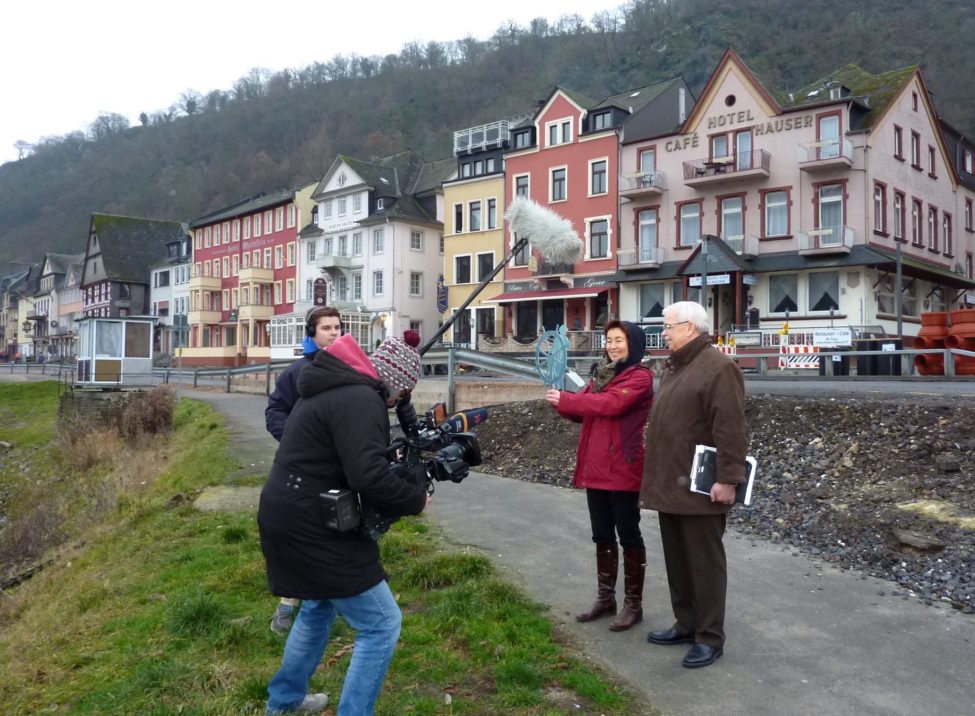 Filmteam, Künsterlin und Bürgermeister am Rheinufer von Sankt Goar